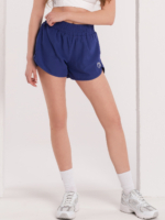 Pantaloni scurți sport de damă, albaștri, cu colanți pe dedesubt și două buzunare laterale.