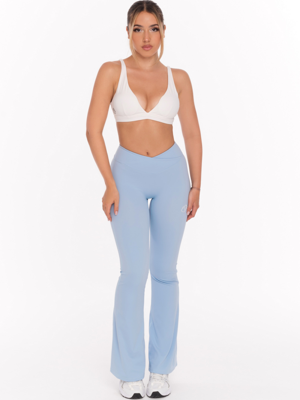 Nowoczesne damskie legginsy typu dzwony w kolorze jasnoniebieskim z talią V, która modeluje sylwetkę.