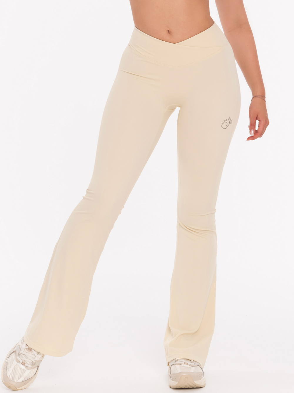 Beżowe legginsy sportowe typu dzwony z talią V, która modeluje sylwetkę